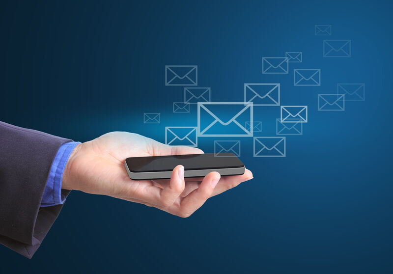 A hand with a mobile phone and envelopes